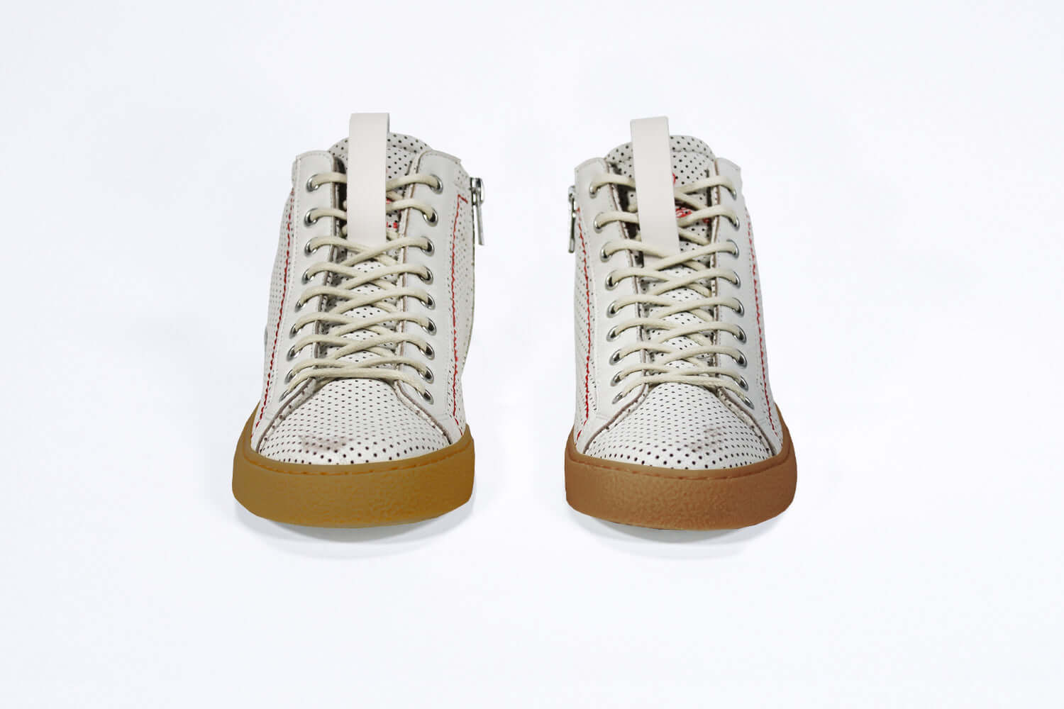 Front view of high top perforated aged white leather sneaker with signature red stitching and a dark natural rubber sole.