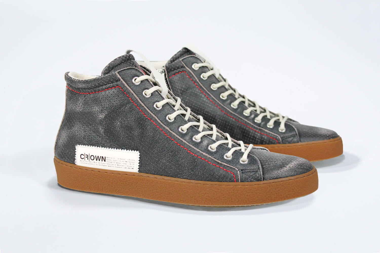 Three quarter front view of high top perforated aged black leather sneaker with signature red stitching and a dark natural rubber sole.