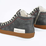 Back view of high top perforated aged black leather sneaker with signature red stitching and a dark natural rubber sole.