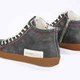 Back view of high top perforated aged black leather sneaker with signature red stitching and a dark natural rubber sole.