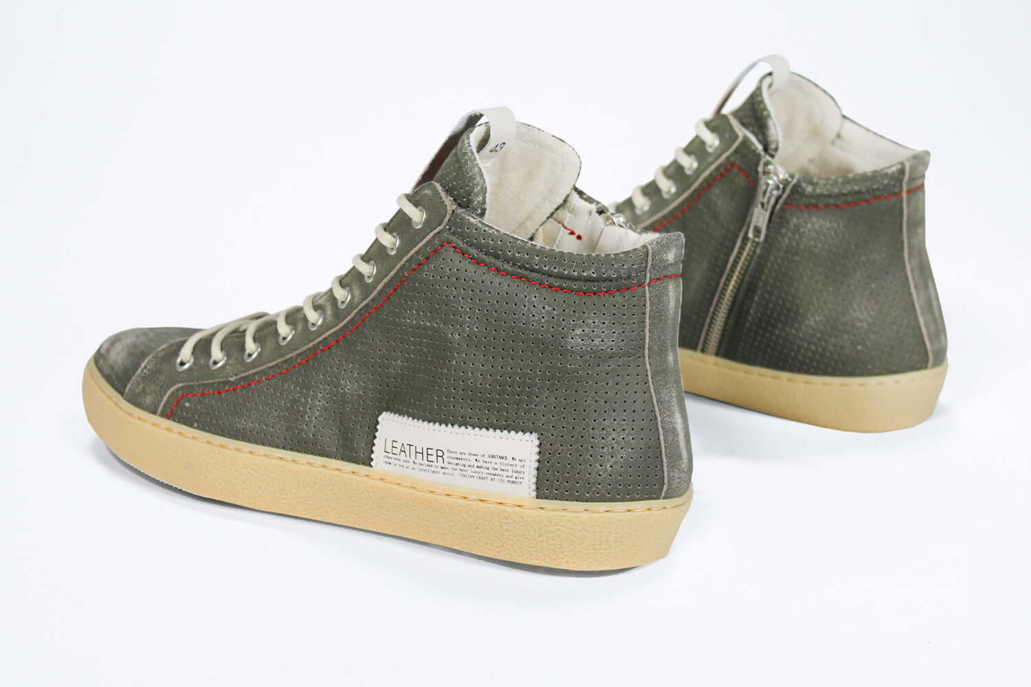 Back view of high top perforated aged khaki leather sneaker with signature red stitching and a pale natural rubber sole.