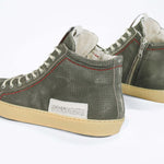 Back view of high top perforated aged khaki leather sneaker with signature red stitching and a pale natural rubber sole.