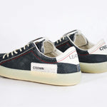 Back view of low top aged navy sneaker with white accents. Perforated navy leather upper with red stitching and pale rubber sole.