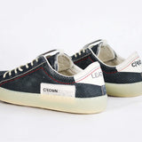 Back view of low top aged navy sneaker with white accents. Perforated navy leather upper with red stitching and pale rubber sole.