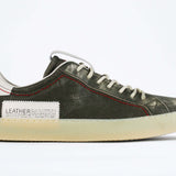 Side profile of low top aged khaki sneaker with white accents. Perforated khaki leather upper with red stitching and pale natural rubber sole.