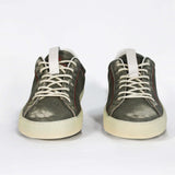 Front view of low top aged khaki sneaker with white accents. Perforated khaki leather upper with red stitching and pale rubber sole.