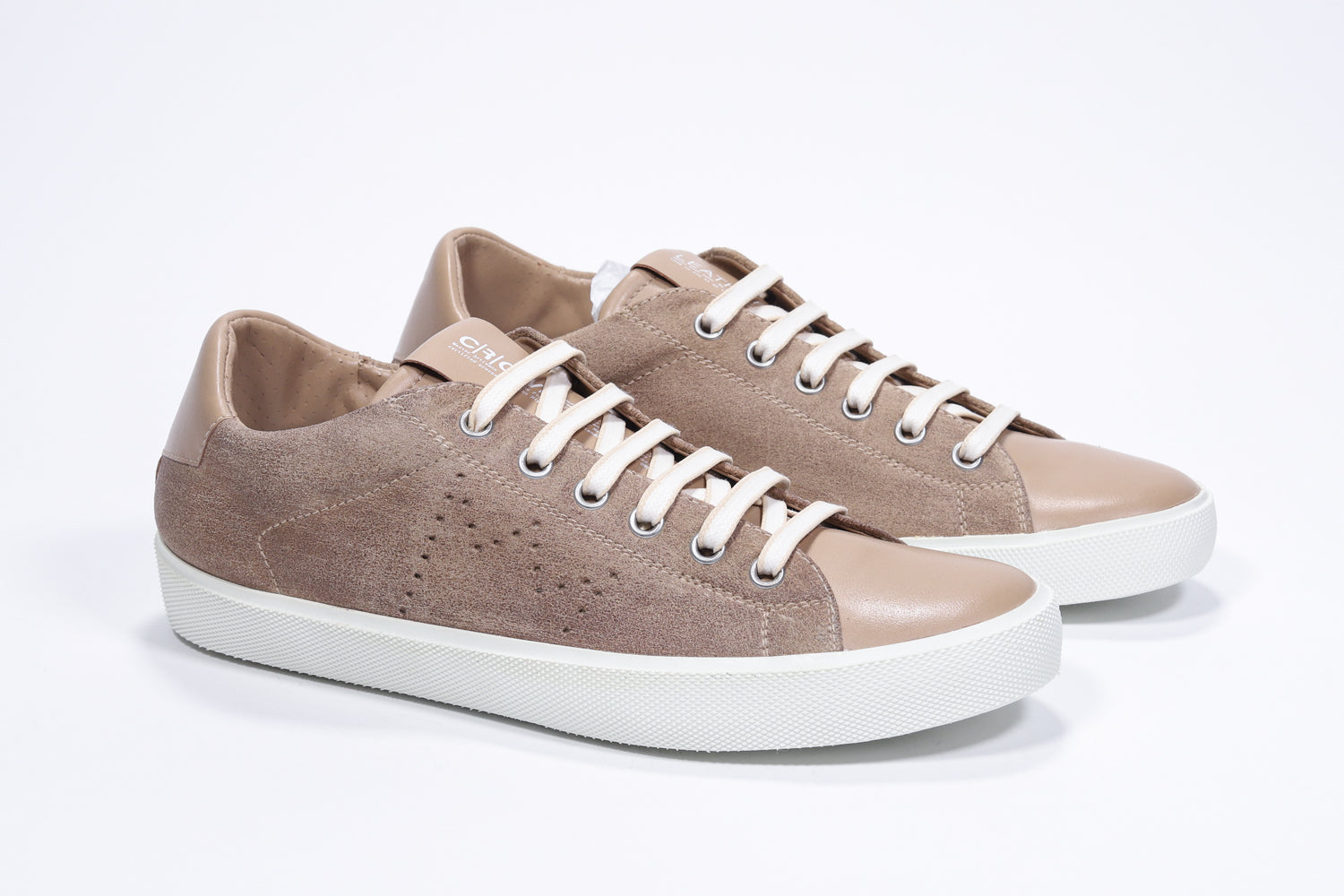 Three quarter front view of low top camel sneaker with perforated crown logo on upper. Full suede upper and white rubber sole.