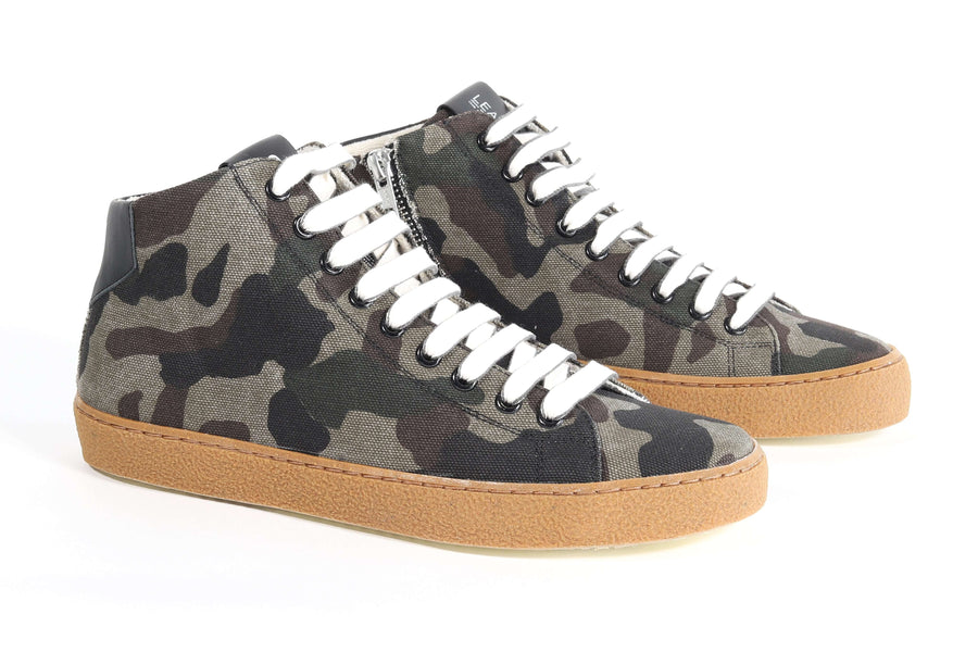 Three quarter front view of mid top camouflage print sneaker with full canvas upper, internal zip and honey colored recycled rubber sole.