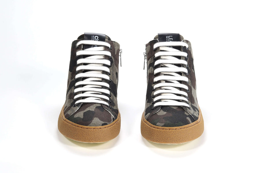 Front view of mid top camouflage print sneaker with full canvas upper, internal zip and honey colored recycled rubber sole.