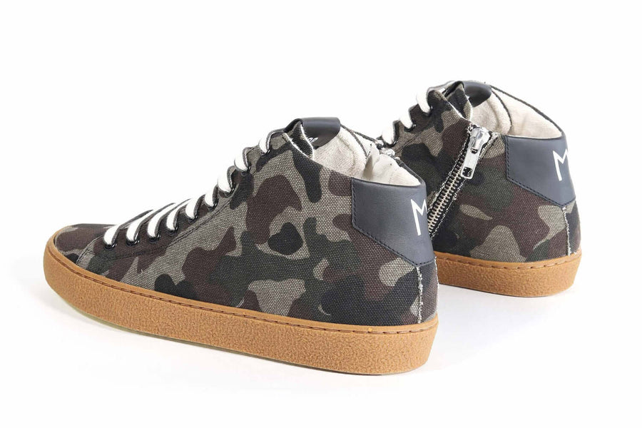 Three quarter back view of mid top camouflage print sneaker with full canvas upper, internal zip and honey colored recycled rubber sole.