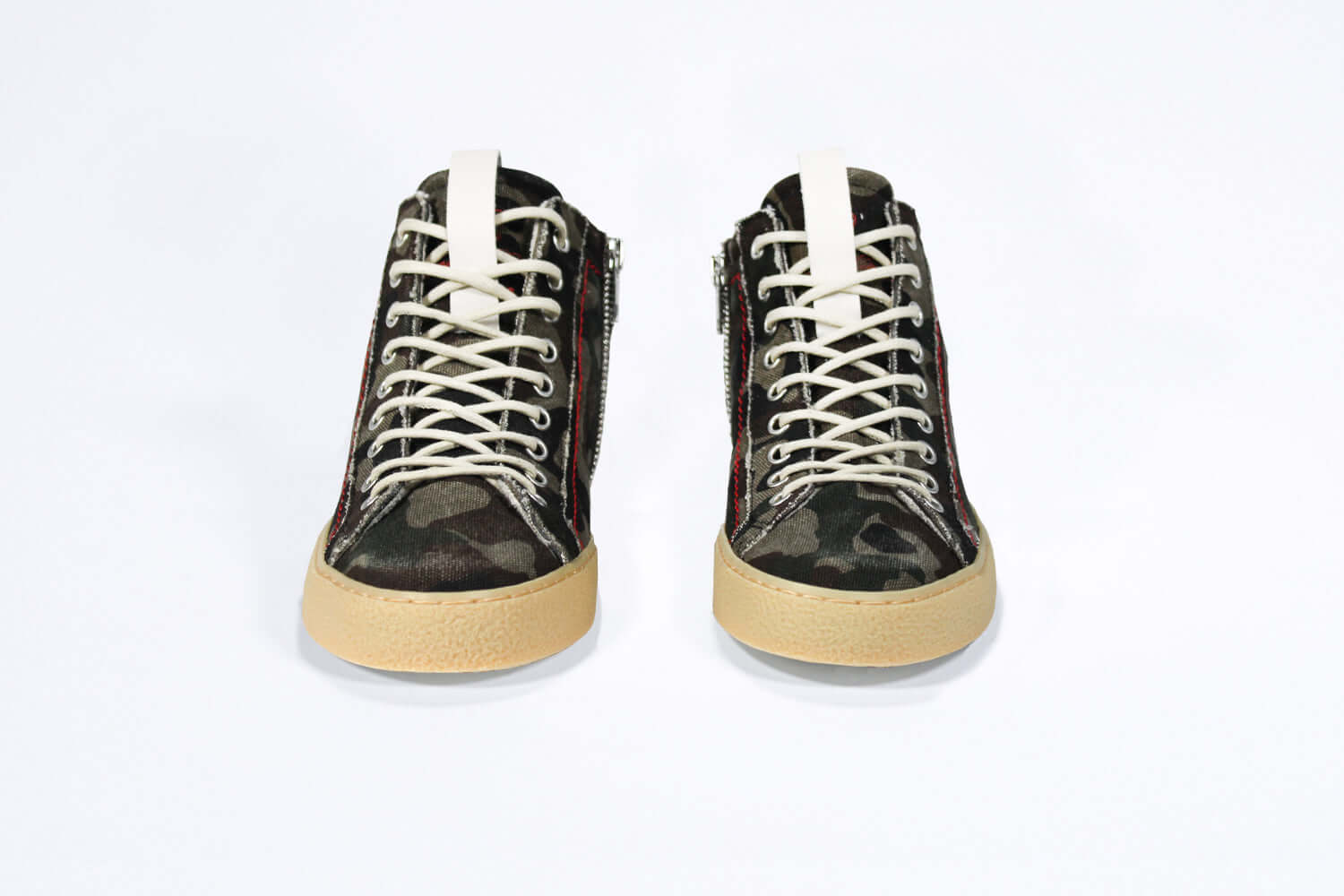 Front view of high top canvas sneaker. Camouflage print canvas upper with signature red stitching and pale natural rubber sole.