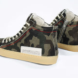 Back view of high top canvas sneaker. Camouflage print canvas upper with signature red stitching and pale natural rubber sole.