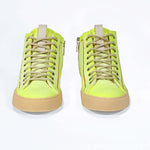 Front view of high top canvas sneaker. Canvas upper hand painted in gradated fluo yellow paint. Pale natural rubber sole.