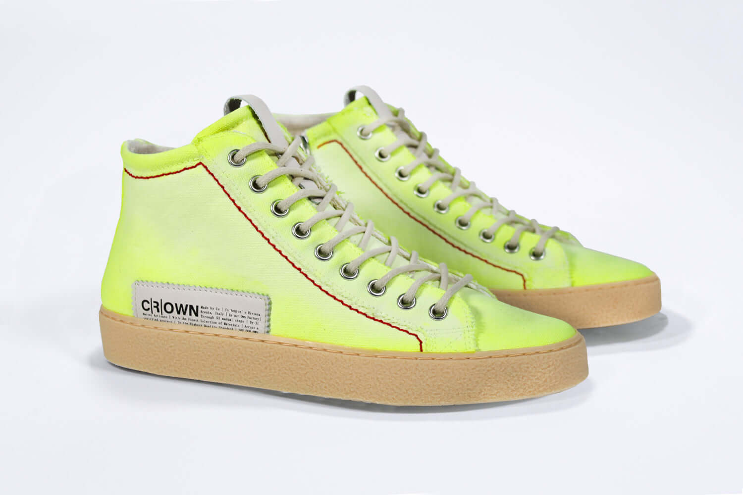 Three quarter front view of high top canvas sneaker. Canvas upper hand painted in gradated fluo yellow paint. Pale natural rubber sole.