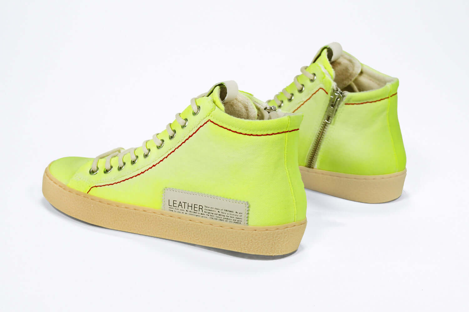 Back view of high top canvas sneaker. Canvas upper hand painted in gradated fluo yellow paint. Pale natural rubber sole.