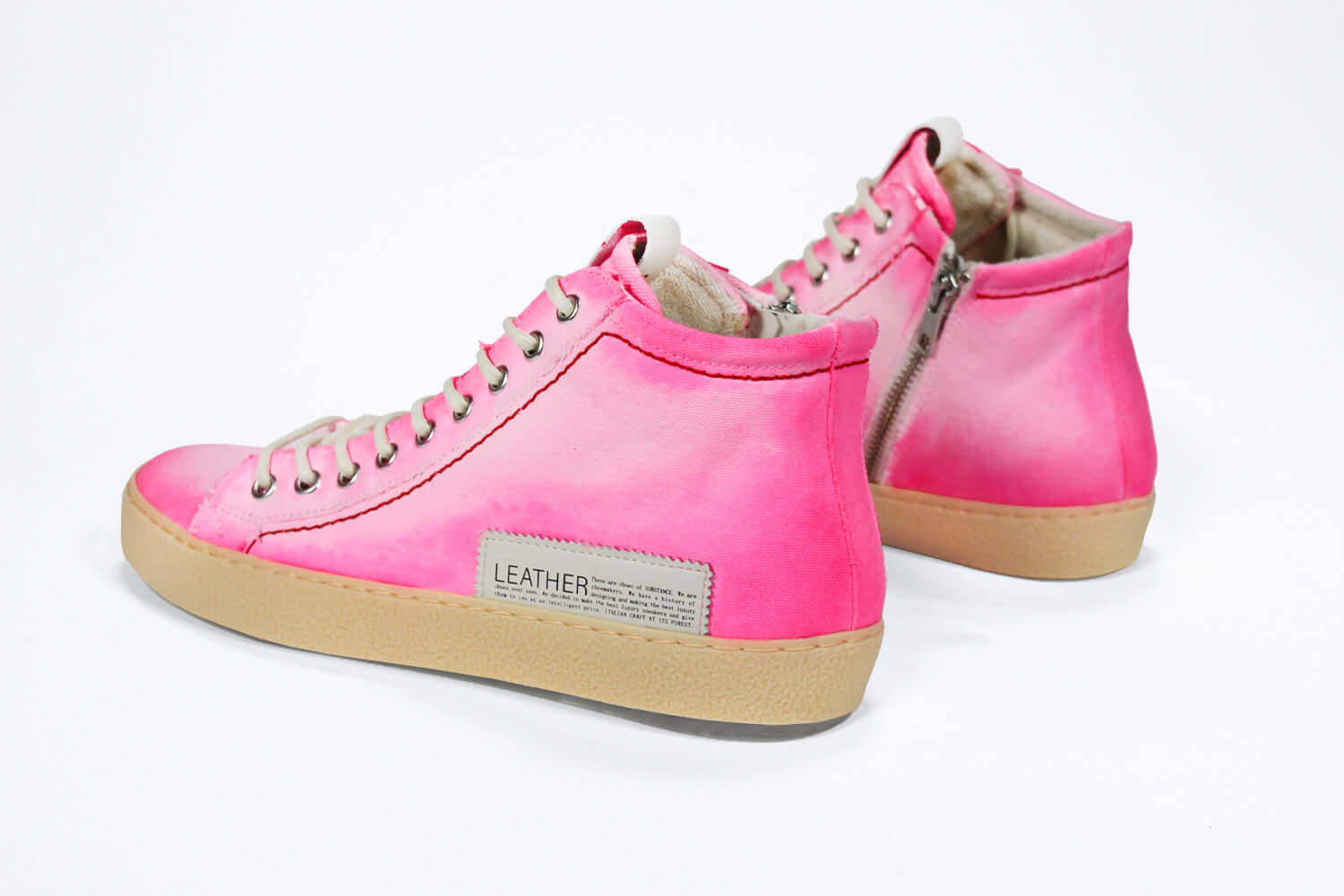 Back view of high top canvas sneaker. Canvas upper hand painted in gradated fluo pink paint. Pale natural rubber sole.
