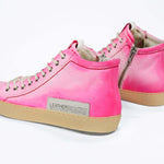 Back view of high top canvas sneaker. Canvas upper hand painted in gradated fluo pink paint. Pale natural rubber sole.