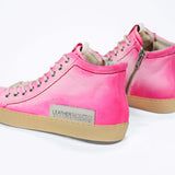 Back view of high top canvas sneaker. Canvas upper hand painted in gradated fluo pink paint. Pale natural rubber sole.