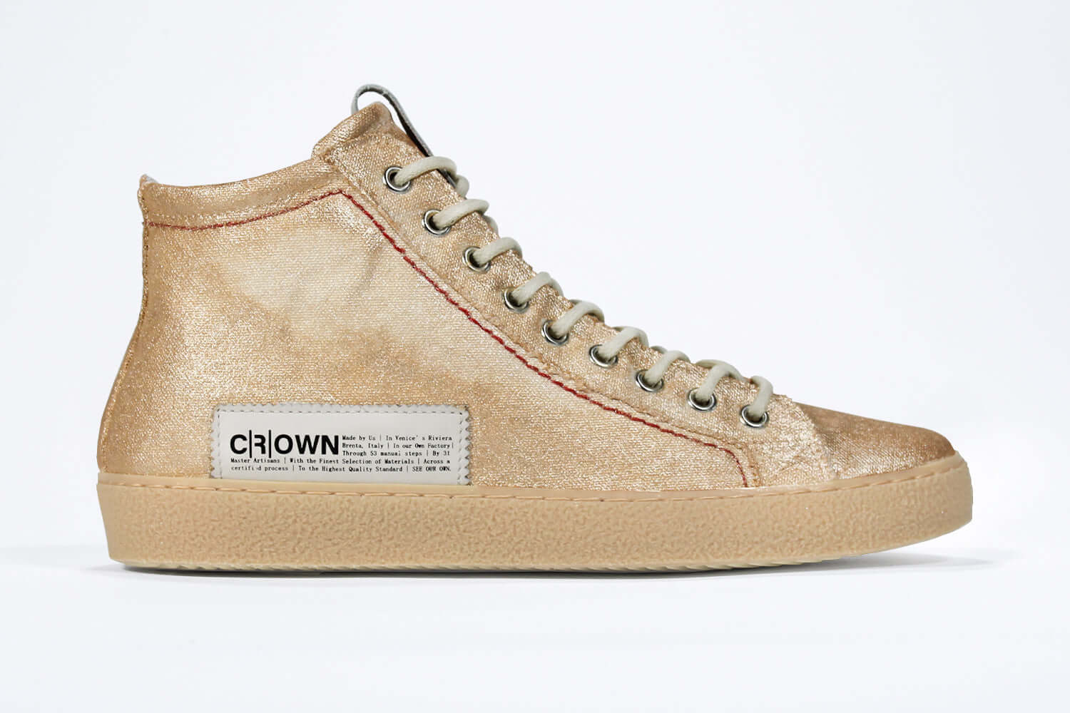 Side profile of high top canvas sneaker. Canvas upper hand painted in gradated gold paint. Natural rubber sole.