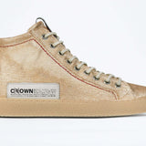 Side profile of high top canvas sneaker. Canvas upper hand painted in gradated gold paint. Natural rubber sole.