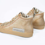 Back view of high top canvas sneaker. Canvas upper hand painted in gradated gold paint. Natural rubber sole.