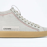 Side profile of high top sneaker. Perforated aged white leather sneakers with signature red stitching and pale natural rubber sole.