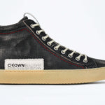 Side profile of high top sneaker. Perforated distressed black leather sneakers with signature red stitching and pale natural rubber sole.