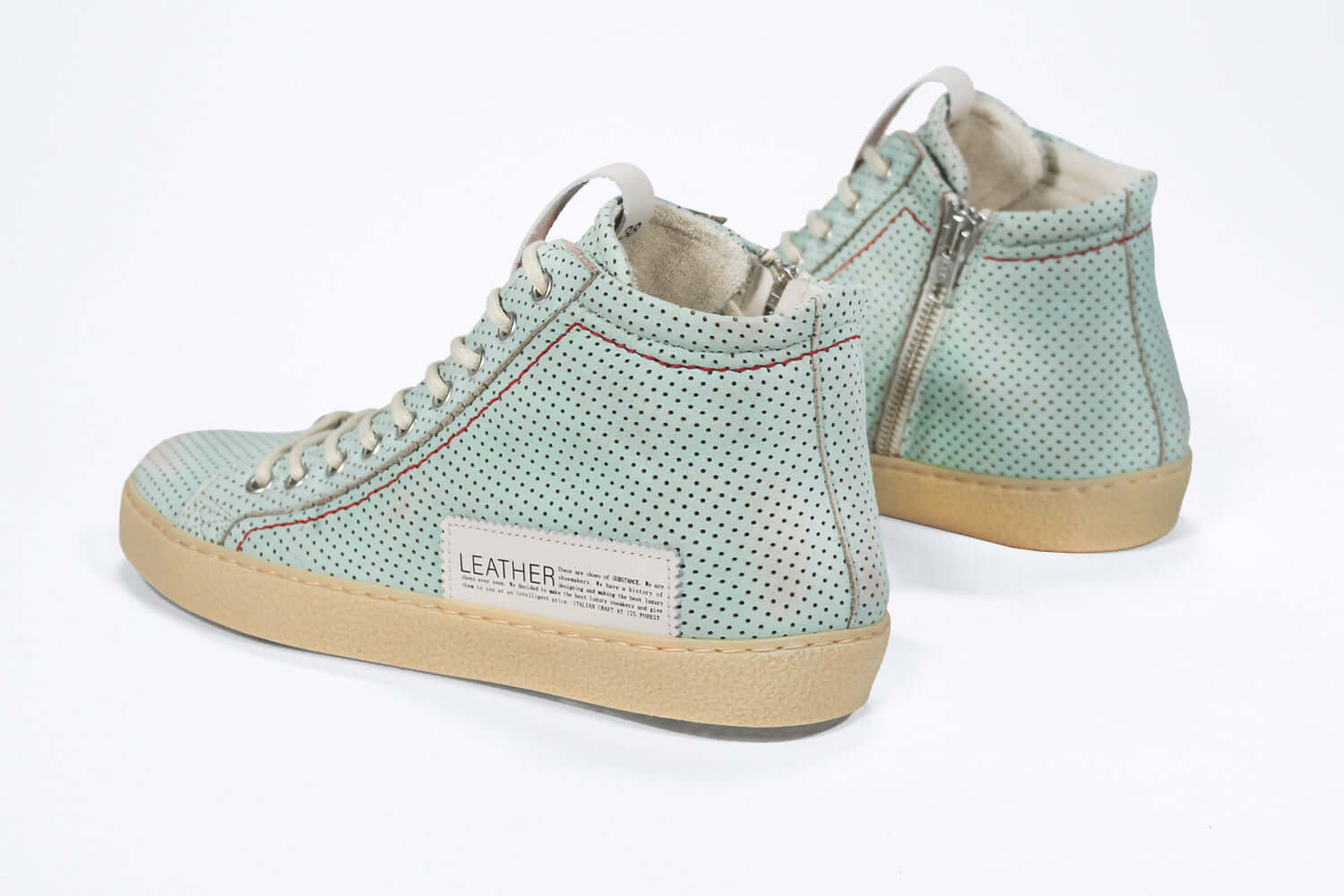 Back view of high top sneaker. Perforated sky blue leather sneakers with signature red stitching and pale natural rubber sole.