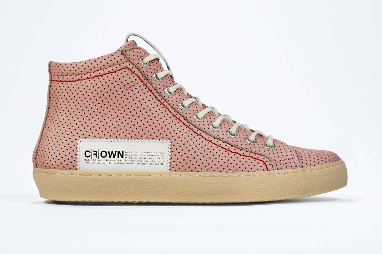 Side profile of high top sneaker. Perforated pink leather sneakers with signature red stitching and pale natural rubber sole.