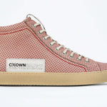 Side profile of high top sneaker. Perforated pink leather sneakers with signature red stitching and pale natural rubber sole.