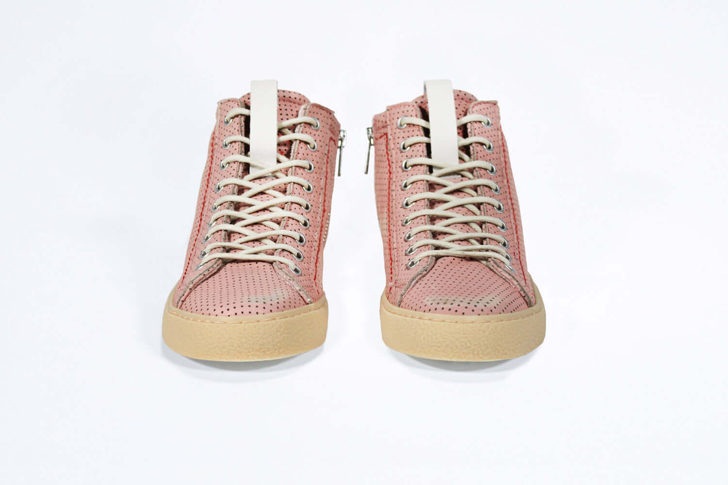 Front view of high top sneaker. Perforated pink leather sneakers with signature red stitching and pale natural rubber sole.