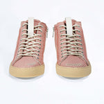 Front view of high top sneaker. Perforated pink leather sneakers with signature red stitching and pale natural rubber sole.