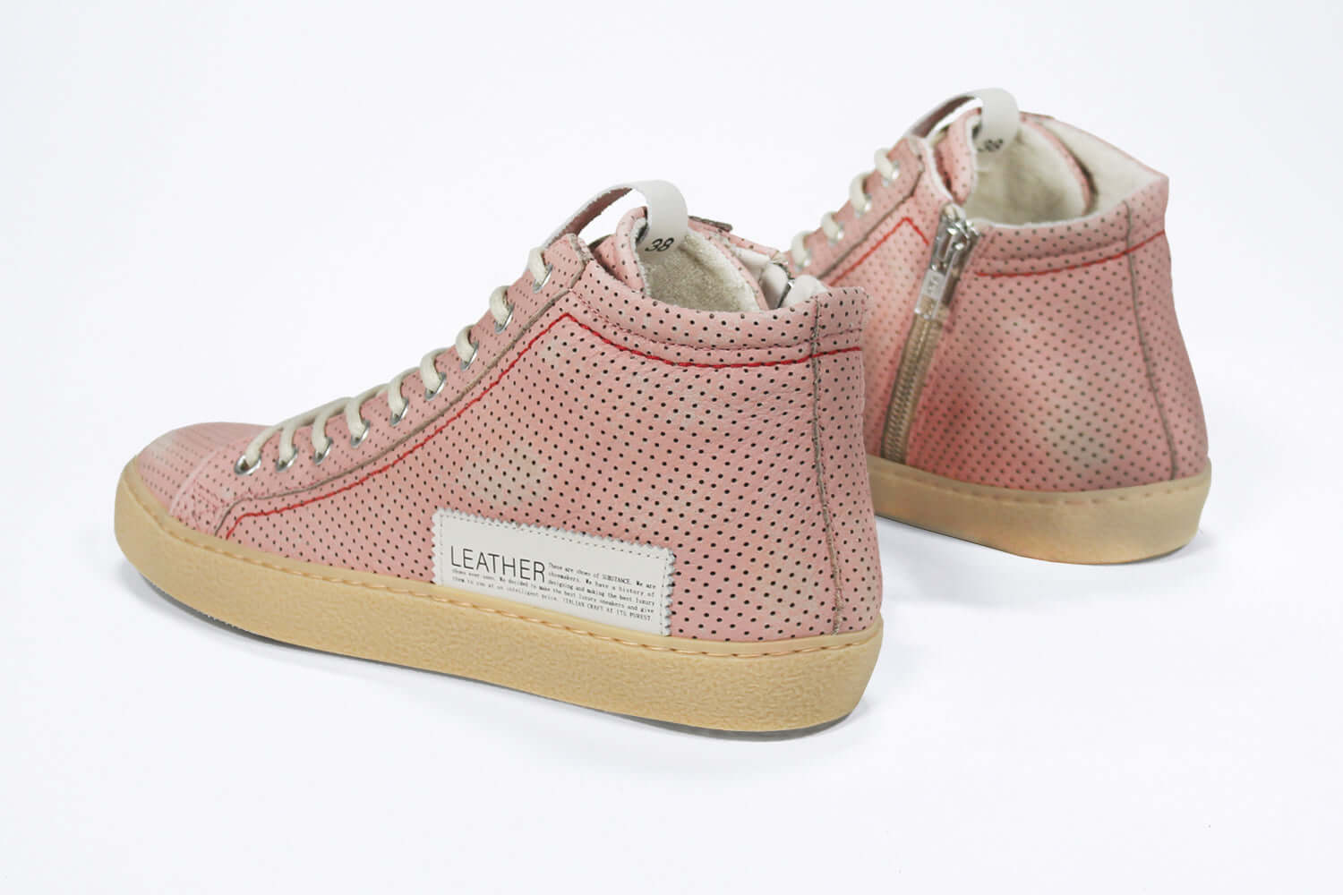 Back view of high top sneaker. Perforated pink leather sneakers with signature red stitching and pale natural rubber sole.