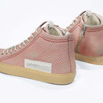 Back view of high top sneaker. Perforated pink leather sneakers with signature red stitching and pale natural rubber sole.