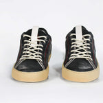 Front view of low top perforated aged black leather sneaker with red stitching detail and a pale natural rubber sole.