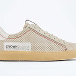 Side profile of low top sneaker. Perforated milk leather sneakers with signature red stitching and pale natural rubber sole.