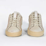 Front view of low top sneaker. Perforated milk leather sneakers with signature red stitching and pale natural rubber sole.