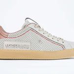 Side profile of low top perforated aged white leather sneaker with blush pink accents, red stitching detail and pale natural rubber sole.