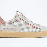 Side profile of low top perforated aged white leather sneaker with blush pink accents, red stitching detail and pale natural rubber sole.