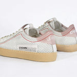 Back view of low top perforated aged white leather sneaker with blush pink accents, red stitching detail and pale natural rubber sole.