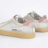 Back view of low top perforated aged white leather sneaker with blush pink accents, red stitching detail and pale natural rubber sole.
