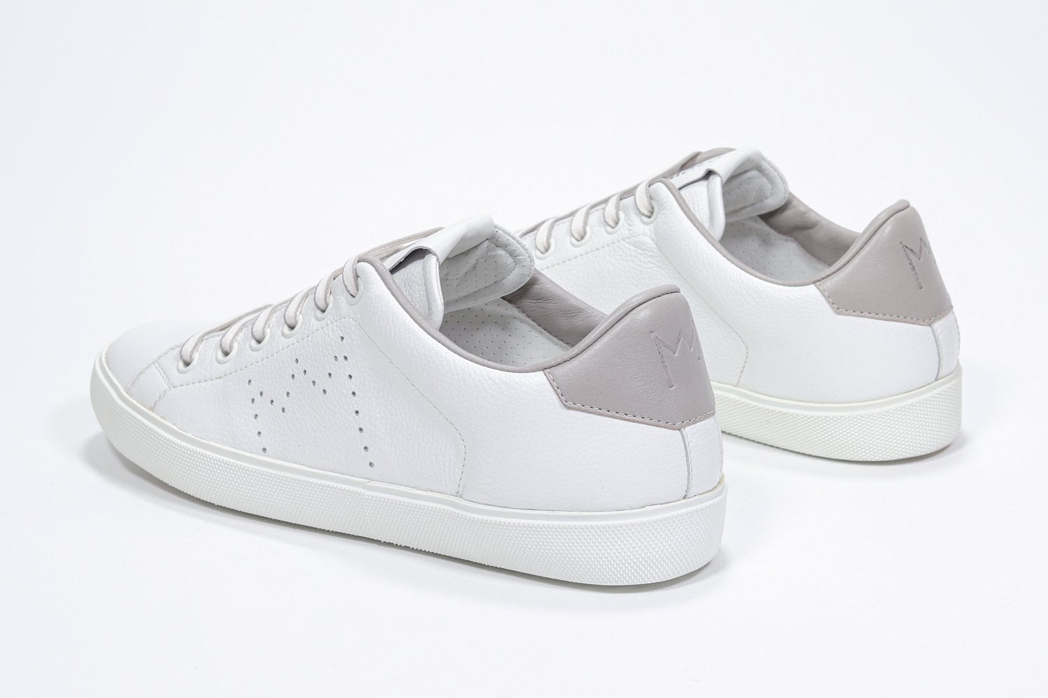 Three quarter back view of low top white sneaker with beige detailing and perforated crown logo on upper. Full leather upper and white rubber sole.