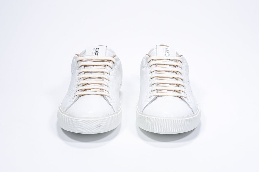 Front view of low top white sneaker with cuoio detailing and perforated crown logo on upper. Full leather upper and white rubber sole.