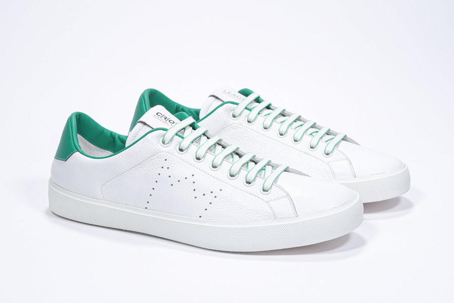 Three quarter front view of low top white sneaker with green detailing and perforated crown logo on upper. Full leather upper and white rubber sole.
