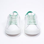 Front view of low top white sneaker with green detailing and perforated crown logo on upper. Full leather upper and white rubber sole.