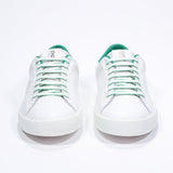 Front view of low top white sneaker with green detailing and perforated crown logo on upper. Full leather upper and white rubber sole.