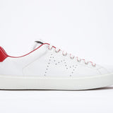 Side profile of low top white sneaker with red detailing and perforated crown logo on upper. Full leather upper and white rubber sole.