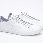 Three quarter front view of low top white sneaker with light grey detailing and perforated crown logo on upper. Full leather upper and white rubber sole.