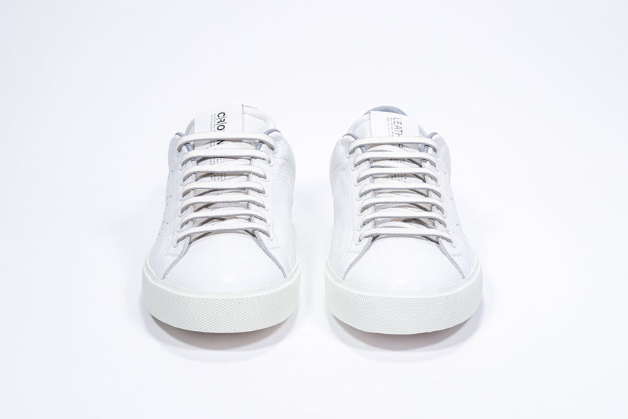 Front view of low top white sneaker with light grey detailing and perforated crown logo on upper. Full leather upper and white rubber sole.