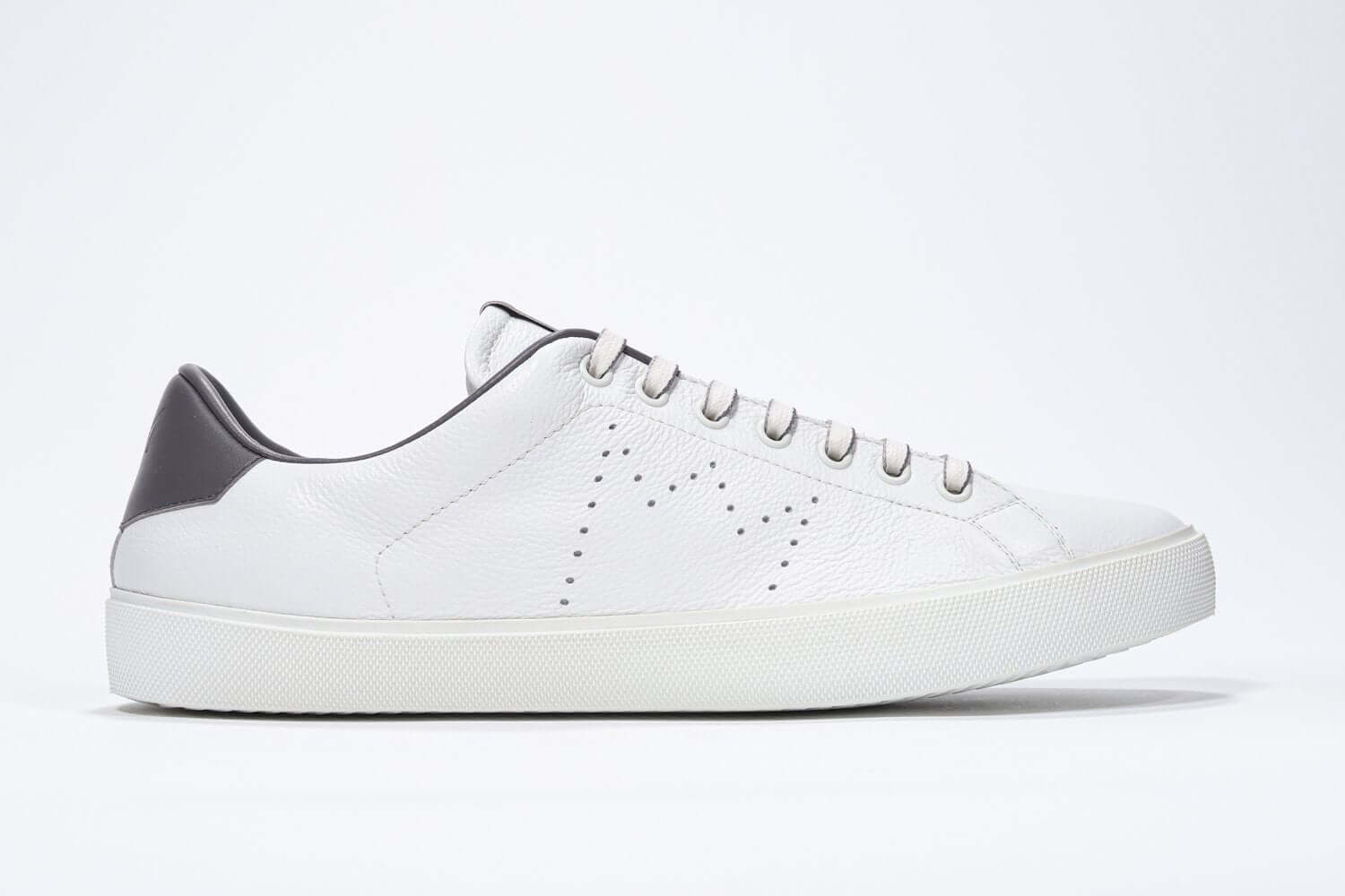 Side profile of low top white sneaker with dark grey detailing and perforated crown logo on upper. Full leather upper and white rubber sole.